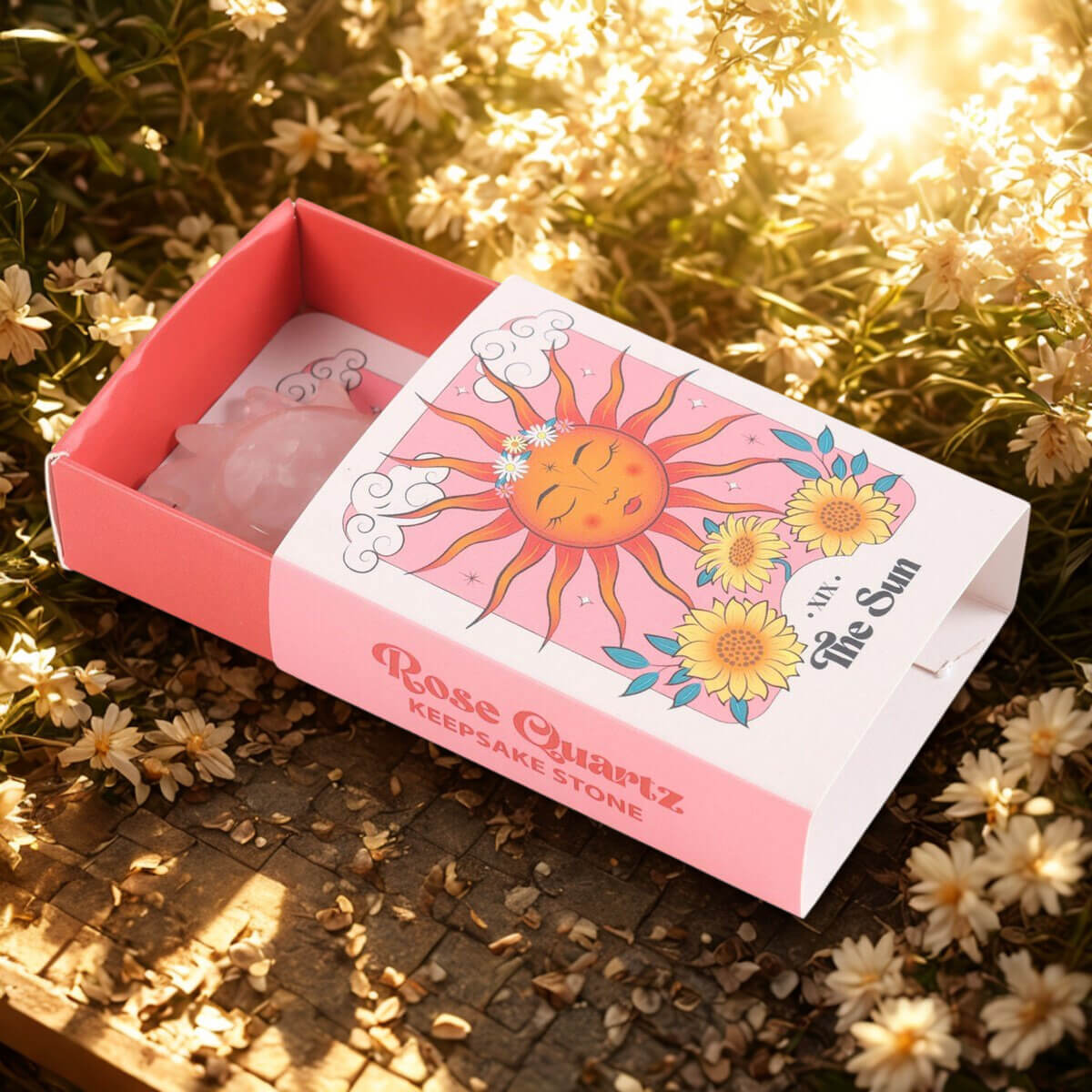 Rose Quartz keepsake stone in a decorative box on grass with flowers